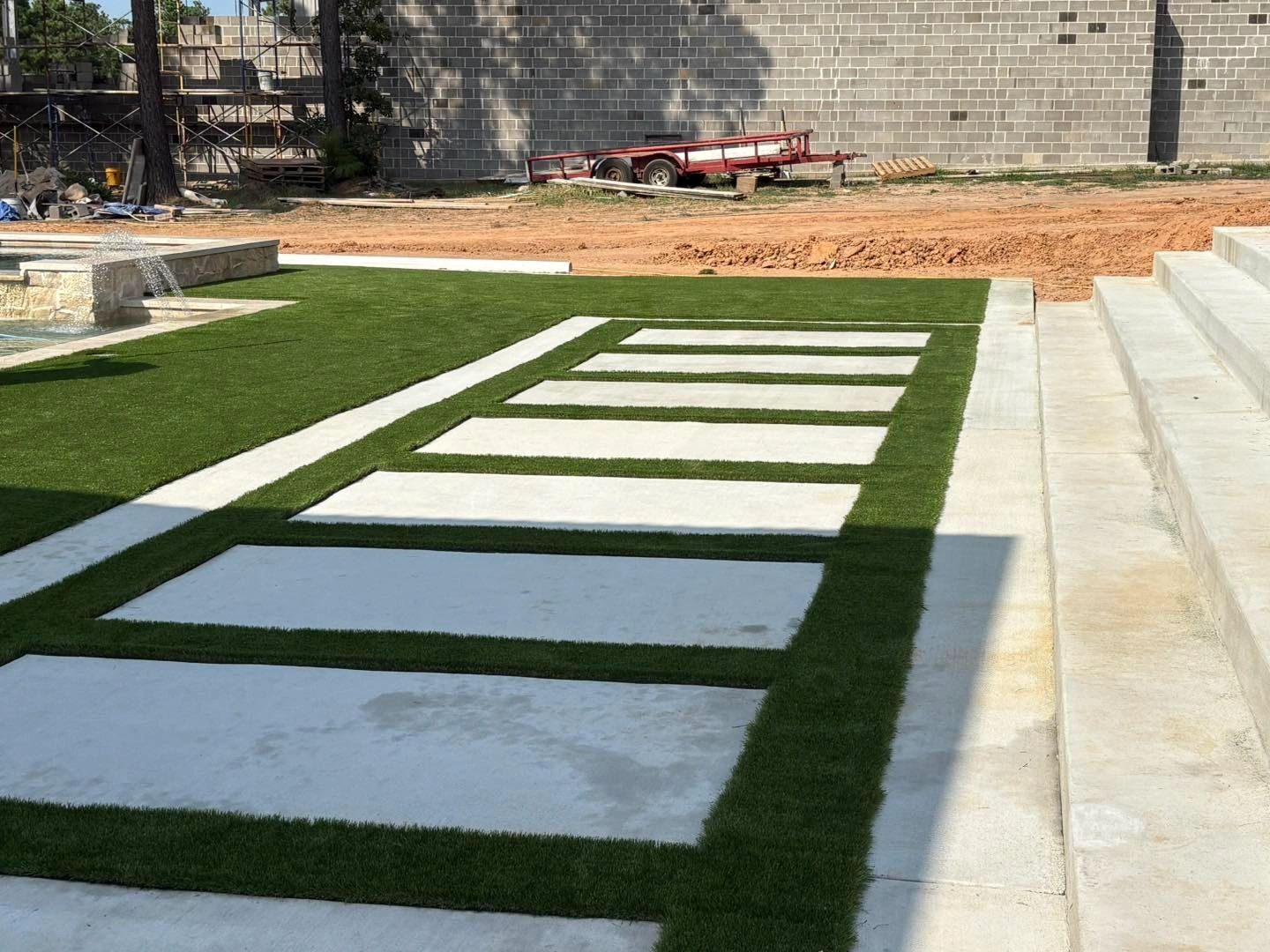 Artificial turf with stepping stone pads beside swimming pool