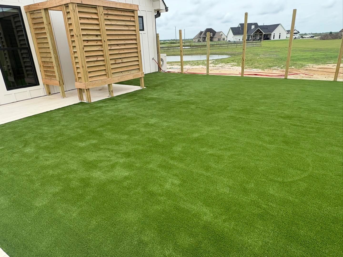 Fresh artificial turf installation on new construction backyard