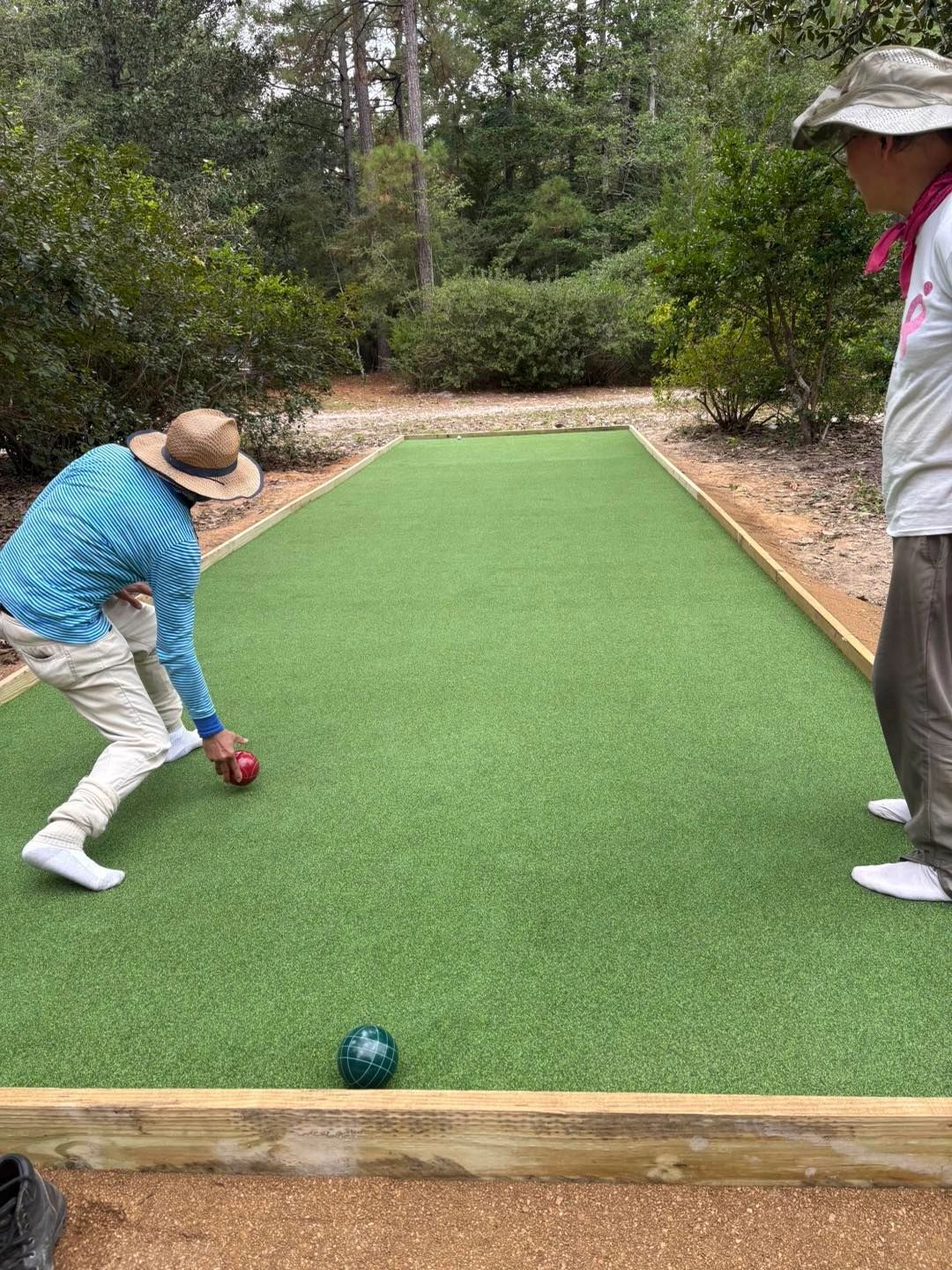 Two people playing bocce ball on custom turf court