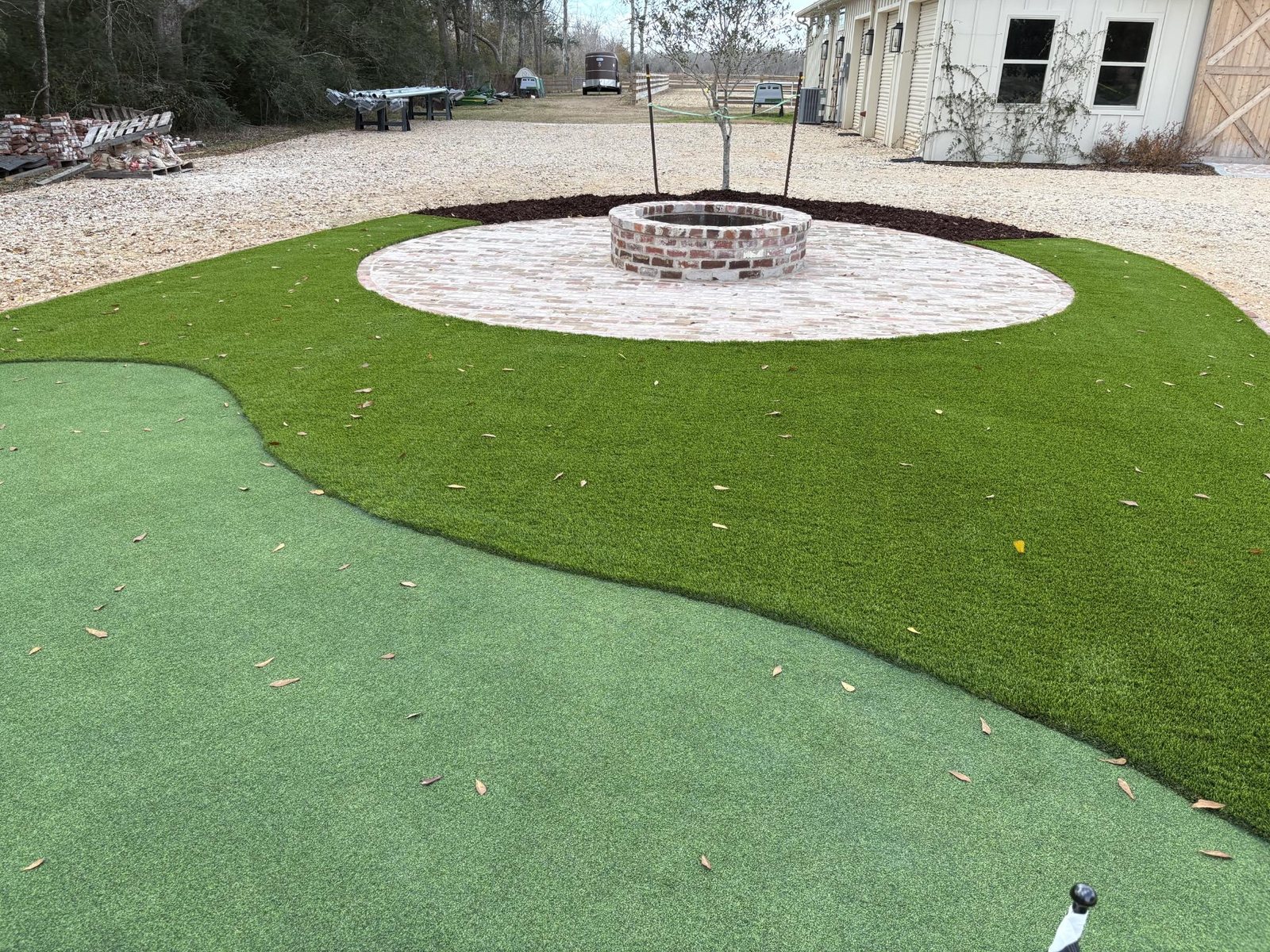 Close up of turf with two-tone putting surface wrapping around brick fire pit